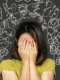 Una persona rilassata sul divano di sera che sorseggia una tisana calda con affiancata la confezione di Biofenix.