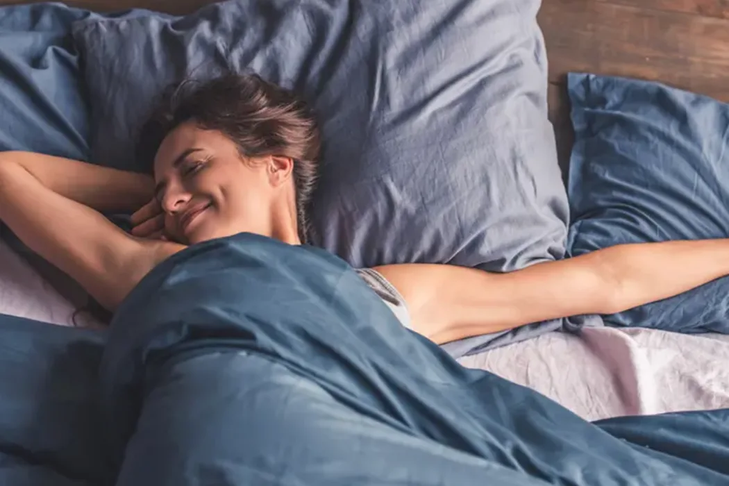 Una persona che dorme serenamente nel proprio letto con affiancata la confezione di Valens per il sonno naturale.